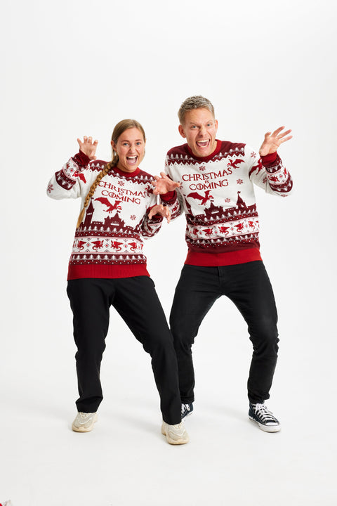 En mand og en dame poserer i deres røde og hvide julesweatre.