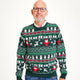 En mand er iført en grøn julesweater ed gaver og juletræer.