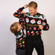 En mand og et barn poserer sammen i matchende julesweatre.