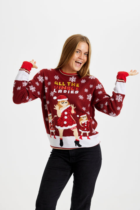 En meget glad dame står med hænderne i vejret og er iført en julesweater med citatet "All My Jingle Ladies".