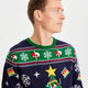 En mand kigger til siden og er iført en julesweater med mønster på.