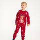 Et barn iført røde julepyjamas.
