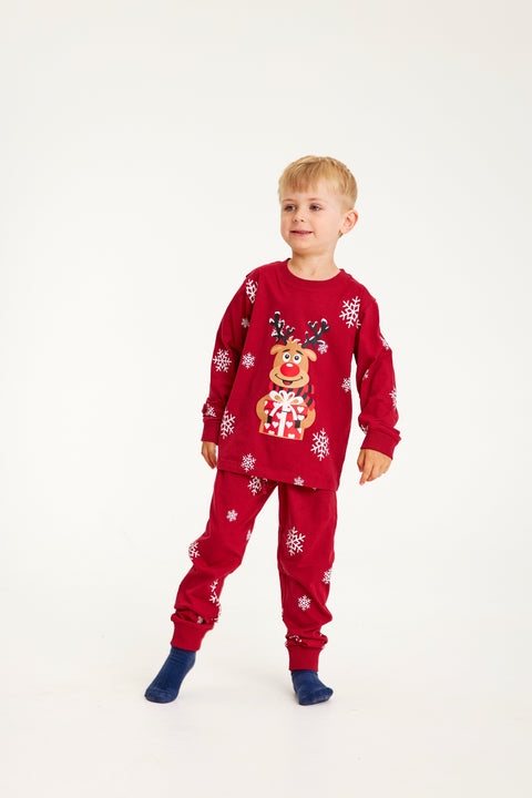 Et barn iført røde julepyjamas.