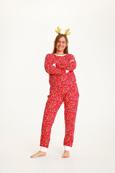 En kvinde med rensdyrgevir er iført en rød julepyjamas med julemønster.
