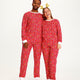 En mand og en kvinde er iført en rød julepyjamas med mønster på.