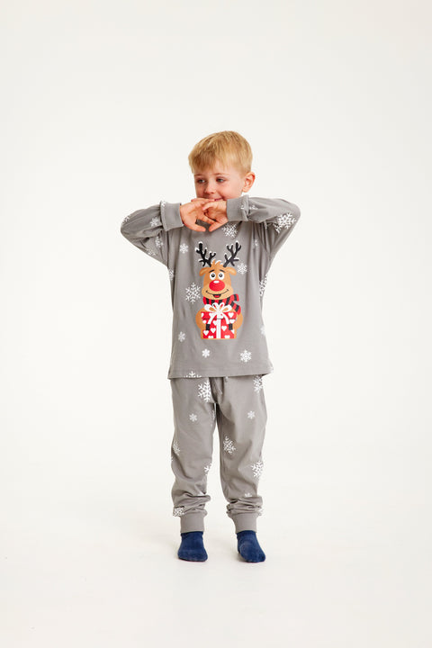Et sødt barn poserer i sine flotte, grå julepyjamas.