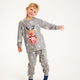 Et barn viser sine grå julepyjamas frem.