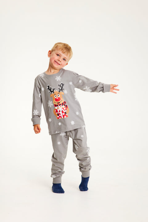 Et barn viser sine grå julepyjamas frem.