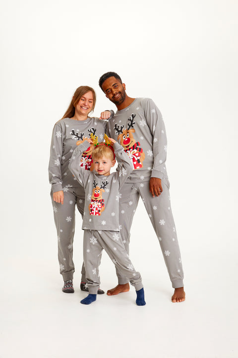 En sødt par og et barn iført grå julepyjamas med rensdyr på.
