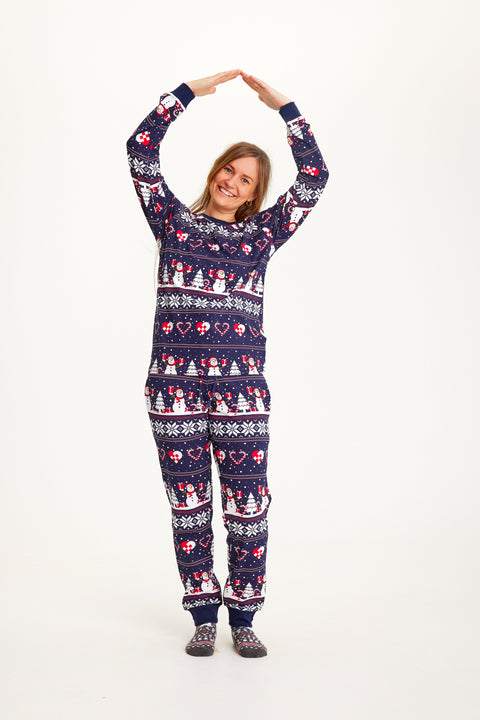 En dame står i en blå, mønstret julepyjamas.