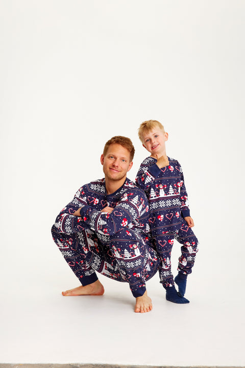En mand og en dreng poserer sammen iført en blå julepyjamas.