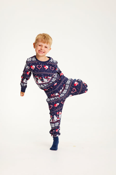 En legende barn med julepyjamas, der har mønster på.
